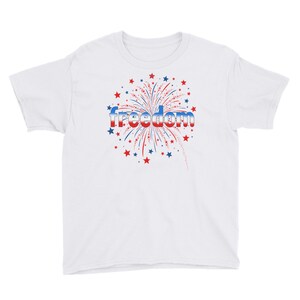 May include: White youth t-shirt with a red, white, and blue firework graphic and the word "freedom" in a silver font.