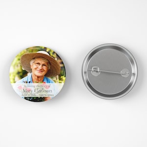 May include: A round button with a photo of a woman wearing a straw hat and a floral print shirt. The text on the button reads "In loving memory of Mary Clarkson June 4, 1944 - May 2, 2023".