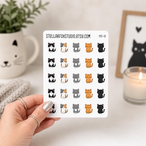 May include: A white sticker sheet featuring five rows of five small, cartoon-style cat illustrations in black, orange, gray, and calico patterns. The text STELLARFOXSTUDIO.ETSY.COM and PET-01 are printed in black at the top of the rectangular sheet.