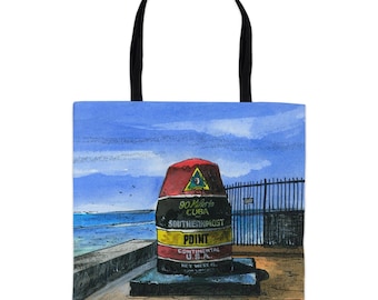 May include: A tote bag featuring a watercolour painting of the Southernmost Point buoy in Key West, Florida. The buoy is red, black, yellow, and white with the text "90 Miles to Cuba, Southernmost Point, Continental U.S.A., Key West, FL".