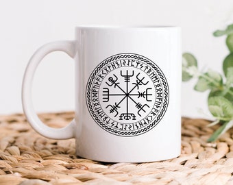 May include: White ceramic mug with a black and white compass design featuring a circle of runes around the compass. The text "Design printed on both sides" is below the mug.