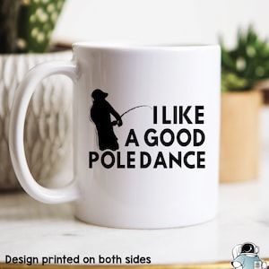 Könnte beinhalten: Eine weiße Keramik-Kaffeetasse mit einer schwarzen Silhouette einer Person beim Angeln und dem Text "Ich mag einen guten Stangen-Tanz".