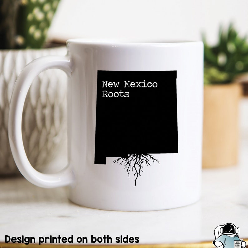 May include: White ceramic mug with a black outline of the state of New Mexico with roots growing from the bottom. The text "New Mexico Roots" is printed in black above the state outline.