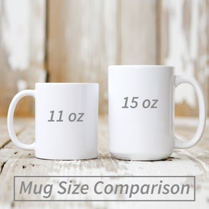 May include: Side-by-side comparison of two white ceramic mugs. The mug on the left is 11 oz and the mug on the right is 15 oz.