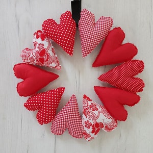 May include: A red and white heart-shaped wreath with a variety of patterns, including polka dots, floral, and houndstooth.