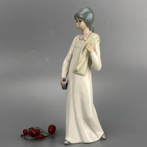 White porelain Casades vintage figurine from Spain of a standing girl holding a bottle