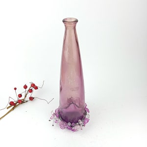 Tall bottle glass purple vase with decor.