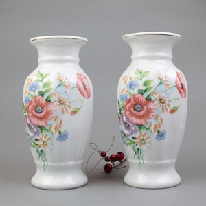 ケシの花飾りで飾られた、中国の白い磁器で作られた優雅な花瓶のペア。