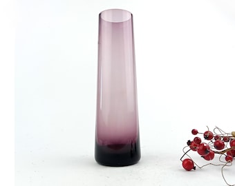 May include: A tall, slender purple glass vase with a rounded bottom.