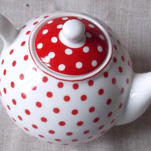 May include: White teapot with a red polka dot pattern and a red lid with white polka dots.