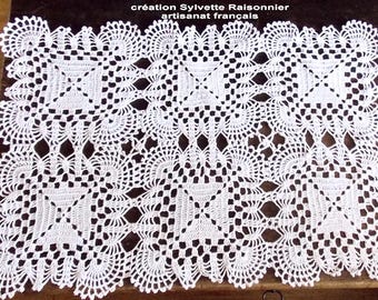 May include: White crocheted doily with a delicate, intricate pattern. The doily is square shaped and has a center design with four smaller squares. The text "création Sylvette Raisonnier artisanat français" is visible at the top of the image.