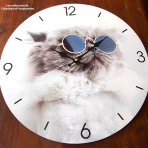 May include: White round clock with a cat wearing sunglasses. The clock face has black numbers 12, 9, 6, and 3.