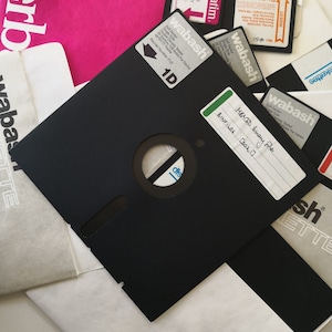 Pode incluir: Um disquete preto com a etiqueta "MBACED Buang File" e o texto "BINFILES 302.1" escrito nele. O disquete &eacute; um disquete de 5,25 polegadas e est&aacute; etiquetado com a marca "wabash".