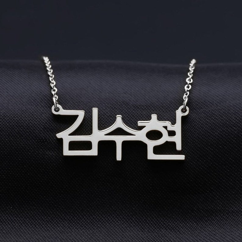 May include: Silver necklace with a Korean word pendant. The word is "잠수현".
