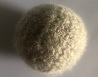 May include: A beige ball of yarn with a fuzzy texture.