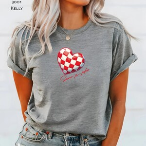 May include: Grey t-shirt with a red and white chequered heart and the text "Samo je jedno" in red.