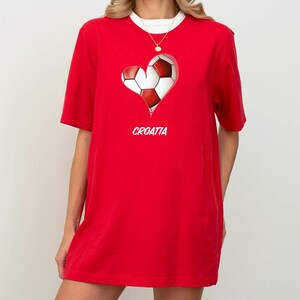 Op de afbeelding: Rood T-shirt met een witte voetbal in de vorm van een hart en het woord "KROATI&Euml;" eronder.
