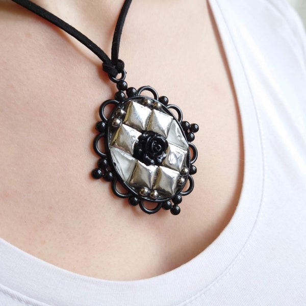 Collier pendentif ovale, cadre baroque noir, rose noir au centre entouré de carreaux de mosaïque miroir argenté et pate de verre blanche.