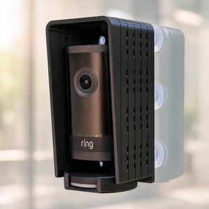 May include: A black cylindrical security camera with the word ring printed on the front, housed within a protective black plastic cover featuring a vented side panel and a top visor, mounted with three clear suction cups on the right side.