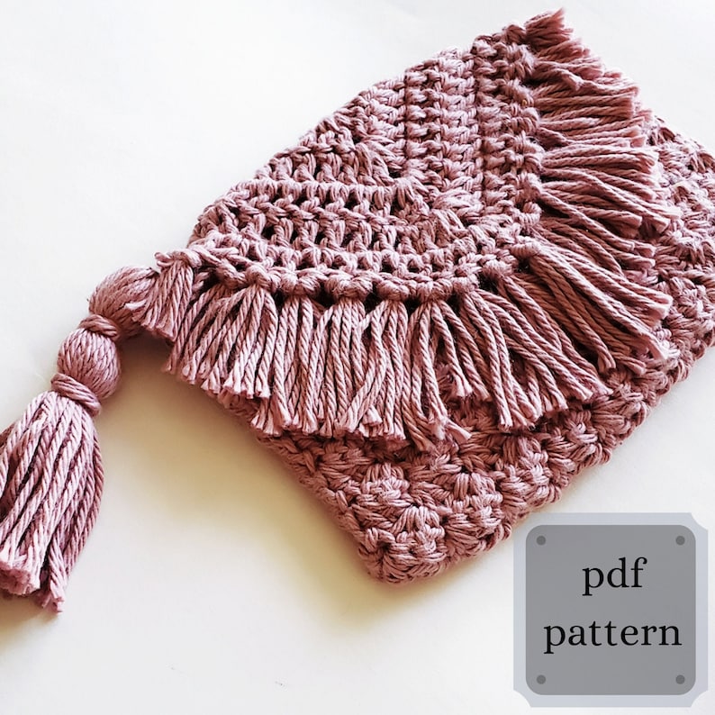 Puede incluir: Una bolsa de crochet con un borla rosa y detalles de flecos. La bolsa est&aacute; hecha con un punto texturizado y tiene un dise&ntilde;o simple y moderno. El texto "pdf pattern" es visible en la esquina inferior derecha de la imagen.