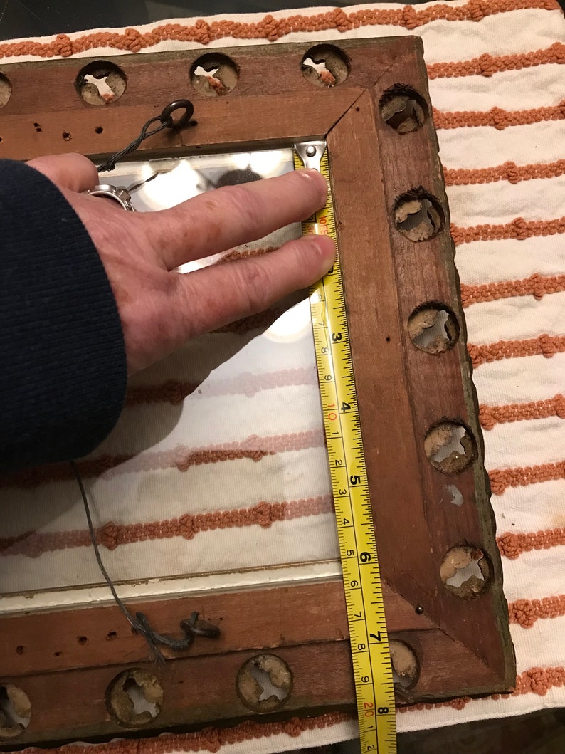 K&ouml;nnte beinhalten: Ein Holzbildrahmen mit einem dekorativen Kreisrand. Der Rahmen ist braun mit einer goldenen Oberfl&auml;che. Der Rahmen ist 20 cm hoch und hat eine Glasscheibe.
