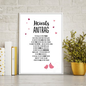 May include: A white framed print with a black and white text design. The text reads "Heirats Antrag" and includes a poem about love and marriage. The print is decorated with pink hearts.