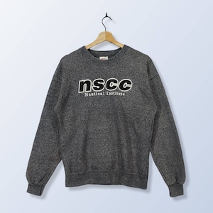 Può includere: Felpa grigia con un logo in bianco e nero che recita "nscc Nautical Institute".
