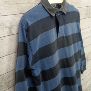 May include: A blue and black striped long-sleeve polo shirt with a button-up collar.