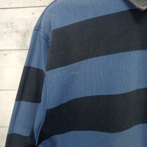 May include: A blue and black striped long-sleeve shirt with a collar.