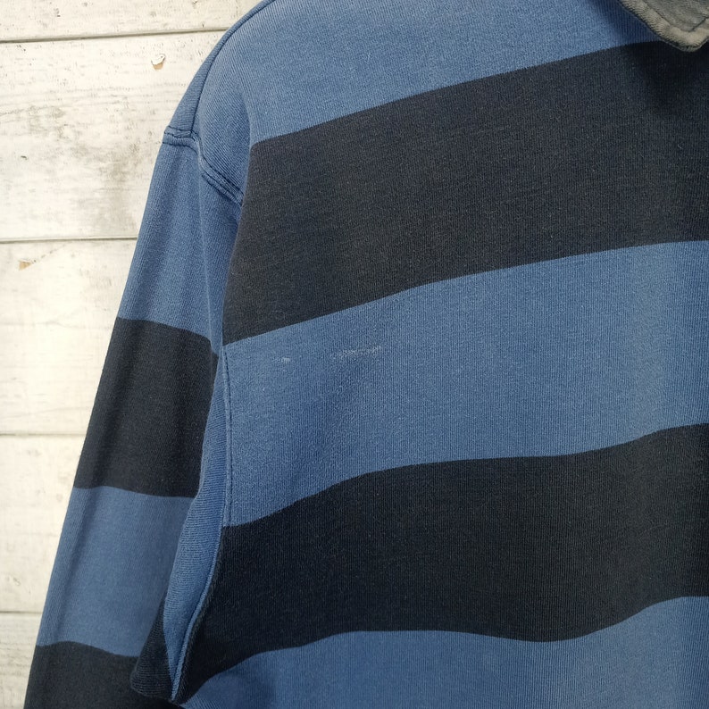 May include: A blue and black striped long-sleeve shirt with a collar.