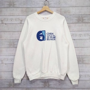 May include: White sweatshirt with a blue and white graphic of a woman's face and the text "CHSN Class of 1961 25 Year Reunion".