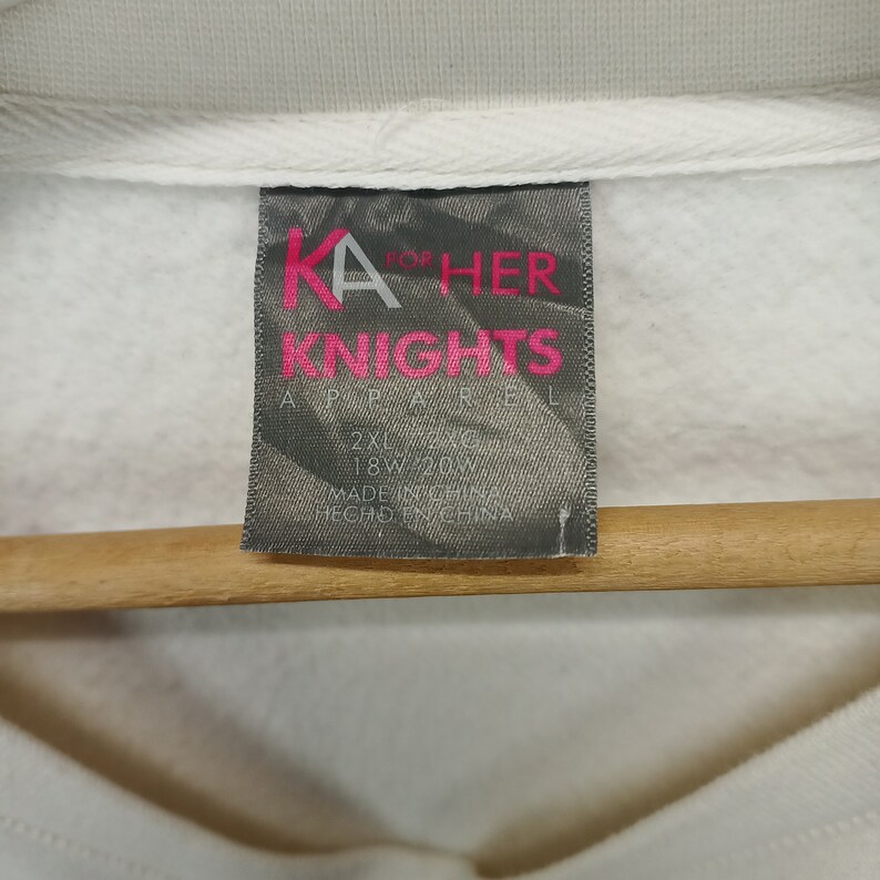 May include: White tag with black and pink text that reads "KA for HER KNIGHTS APPAREL 2XL 22/26 18W 20W MADE IN CHINA HECHO EN CHINA"