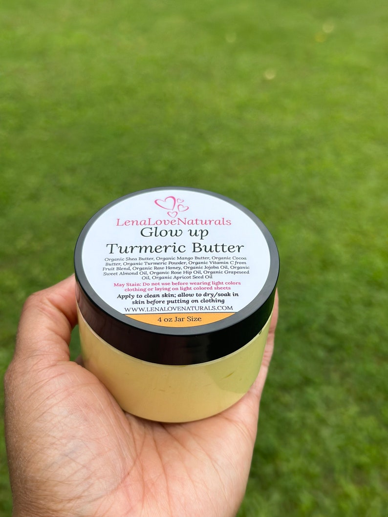 May include: A 4 ounce jar of turmeric butter labeled "LenaLoveNaturals Glow up Turmeric Butter". The jar is yellow and has a black lid. The label lists the ingredients, which include shea butter, mango butter, cocoa butter, turmeric powder, vitamin C, raw honey, jojoba oil, sweet almond oil, rose hip oil, grapeseed oil, and apricot seed oil. The label also states that the product may stain and should not be used before wearing light colors. It instructs the user to apply the butter to clean skin and allow it to dry or soak in before putting on clothing. The website address is listed as www.lenalovenaturals.com.