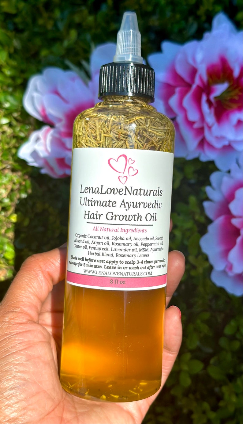 May include: A clear glass bottle with a black cap and a label that reads "Lena Love Naturals Ultimate Ayurvedic Hair Growth Oil". The bottle is filled with a yellow liquid and contains herbs. The label lists all-natural ingredients and instructions for use. The bottle is 8 fl oz.