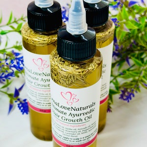 Puede incluir: Tres botellas de vidrio de aceite para el crecimiento del cabello con goteros transparentes y tapas negras. Las botellas est&aacute;n llenas de un aceite amarillo claro y contienen hierbas. La etiqueta dice "EnaLove Naturals Ultimate Ayurvedic Hair Growth Oil. All Natural Ingredients".