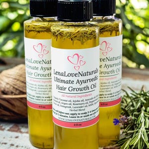 May include: Three 4-ounce bottles of Lena Love Naturals Ultimate Ayurvedic Hair Growth Oil. The bottles are clear glass and contain a yellow liquid. The labels are white with pink hearts and black text. The bottles are sitting on a wooden surface with green foliage in the background.