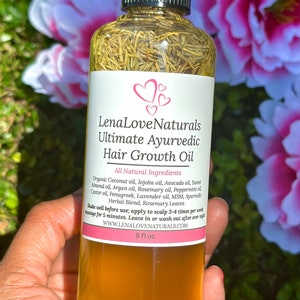 May include: A clear glass bottle with a black cap and a label that reads "Lena Love Naturals Ultimate Ayurvedic Hair Growth Oil". The bottle is filled with a yellow liquid and contains herbs. The label lists all-natural ingredients and instructions for use. The bottle is 8 fl oz.