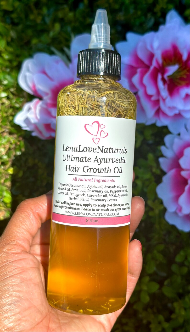 May include: A clear glass bottle with a black cap and a label that reads "Lena Love Naturals Ultimate Ayurvedic Hair Growth Oil". The bottle is filled with a yellow liquid and contains herbs. The label lists all-natural ingredients and instructions for use. The bottle is 8 fl oz.