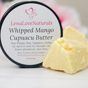 May include: A white jar with a black lid and a label that reads "LenaLoveNaturals Whipped Mango Cupuacu Butter". The label lists the ingredients: Raw Mango, Raw Cupuacu, Jojoba oil, Apricot seed oil, Avocado oil, Sweet almond oil, Aloe Vera. The jar is sitting on a white surface next to three chunks of white butter.