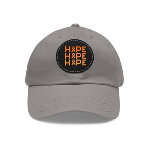 May include: A grey baseball cap with a black and orange patch that says "HOPE" three times with a ribbon design.