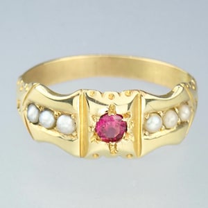 May include: A gold ring with a red gemstone in the centre and a row of pearls on each side.