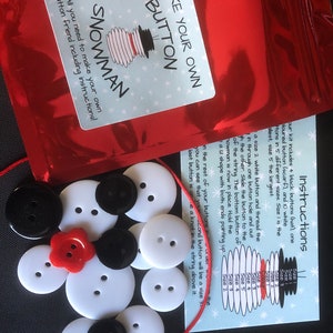 May include: A craft kit to make a snowman out of buttons. The kit includes white buttons in various sizes, black buttons for the hat, a red button for the nose, and a red string. The instructions are included on a card with a snowman illustration and a size chart for the buttons.