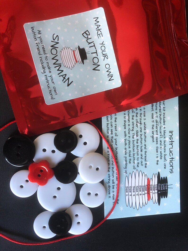 May include: A craft kit to make a snowman out of buttons. The kit includes white buttons in various sizes, black buttons for the hat, a red button for the nose, and a red string. The instructions are included on a card with a snowman illustration and a size chart for the buttons.