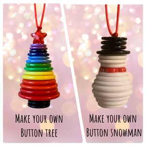 May include: Two Christmas ornaments made from buttons. One is a rainbow button Christmas tree and the other is a white button snowman. Both ornaments have red string for hanging.