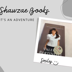 May include: A white Polaroid photo featuring a woman holding a book titled "Losing It" by Valerie Bertinelli. The book cover is brown with white text. The photo has the text "Smiles" written below the image.