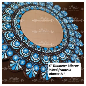 Peut inclure: Un miroir de 12,7 cm de diamètre avec un motif de mandala bleu et blanc peint sur un cadre en bois brun. Le cadre mesure presque 28 cm de diamètre.
