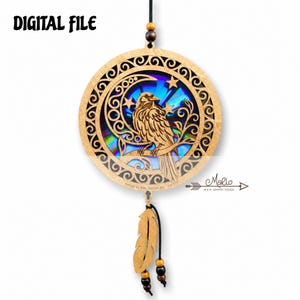 May include: A circular wooden hanging ornament featuring a laser-cut raven perched on a branch with a crescent moon and stars. The center has an iridescent rainbow finish. It includes a wooden feather charm, black cord, and beads. Text reads DIGITAL FILE.