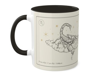 May include: White ceramic mug with a black rim and handle. The mug features a black and white illustration of a scorpion with the zodiac symbol for Scorpio and the words "Powerful / Careful / Brilliant".