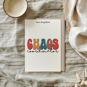 Könnte beinhalten: Eine weiße Karte mit dem Text "Dein Bügelbild" oben und dem Text "CHAOS coordinator" in bunten, Retro-Lettern darunter. Die Karte liegt auf einer hellbraunen Stoffoberfläche.
