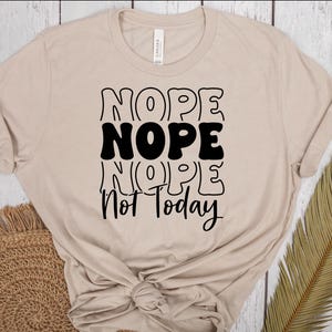 Könnte beinhalten: Ein beiges T-Shirt mit schwarzem Text, der "NOPE NOPE NOPE Not Today" lautet.